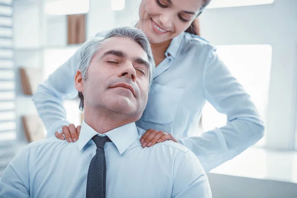 Spokojení zaměstnanci, kteří mají příjemnou masáž v práci — Stock fotografie