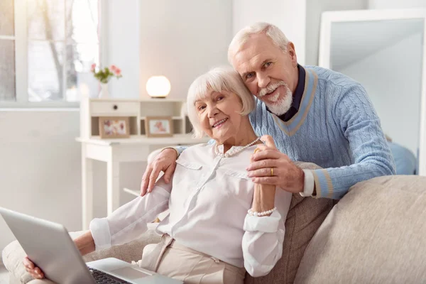 Ancianos hermosa pareja viendo fotos en el portátil — Foto de Stock