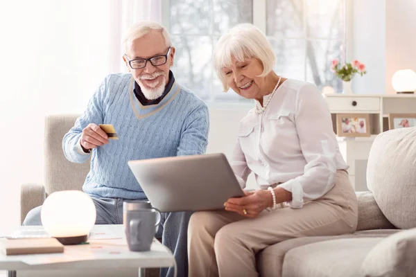 Paar van gepensioneerden op zoek via de foto's op de laptop — Stockfoto