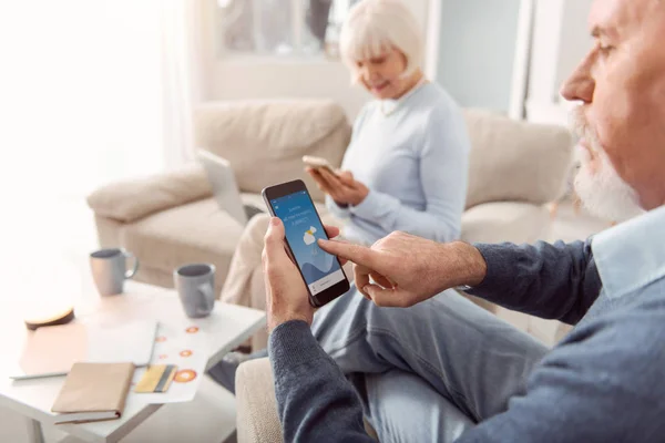 Pareja de pensionistas jugando en los teléfonos inteligentes — Foto de Stock