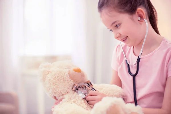 Close up of beautiful cute little daughter playing with her little toy — Stock Photo, Image