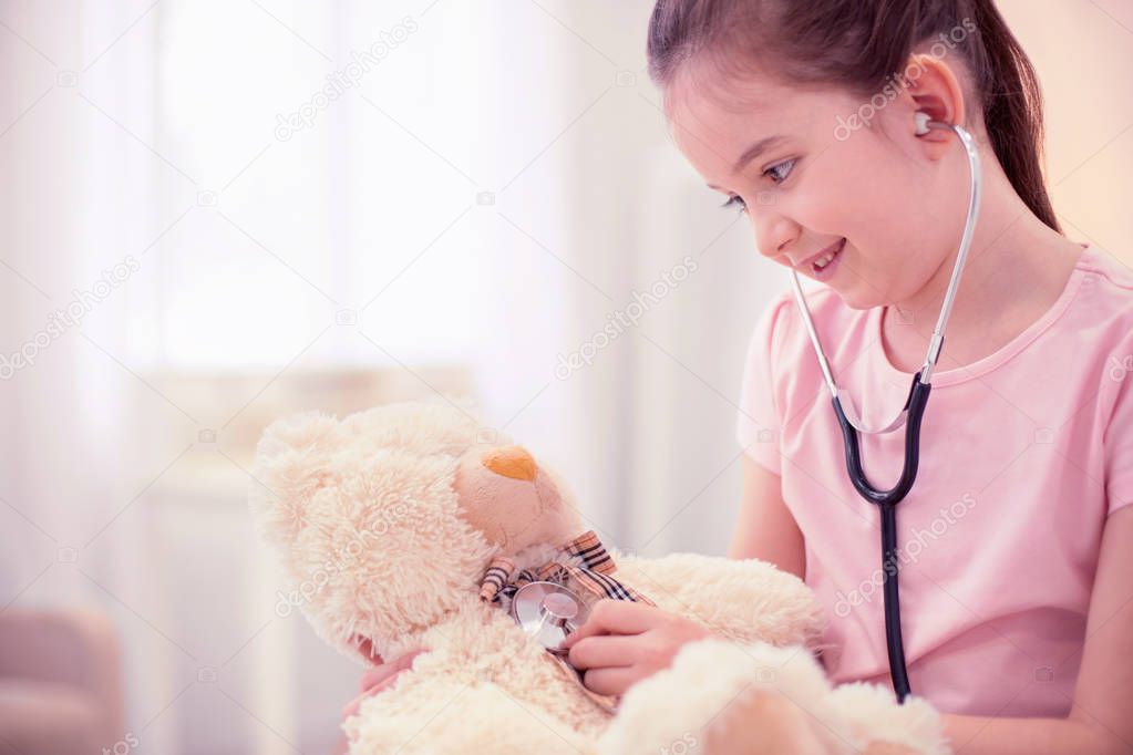 Close up of beautiful cute little daughter playing with her little toy