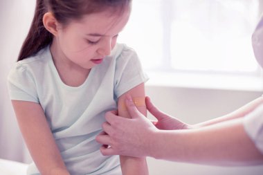 Yapışkan bant üzerinde küçük kızının el koyarak annelerin bakım