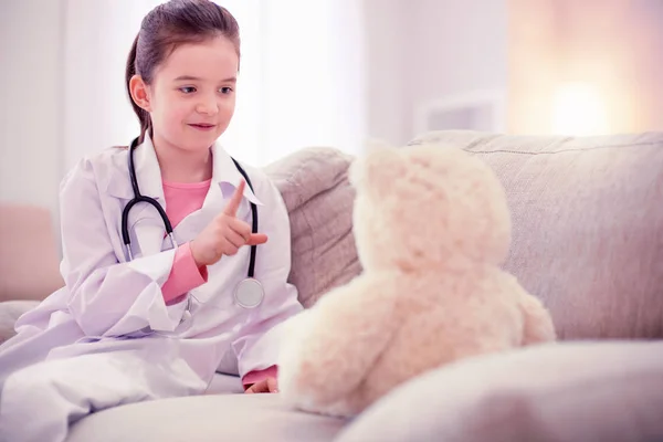 Cute little girl sitting at home alone playing with her teddy bear — Stock Photo, Image