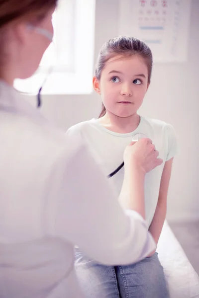 Mädchen hält den Atem an, während der Hausarzt auf ihre Lungen hört — Stockfoto