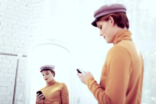 Pohledný mladík queer SMS s jeho smartphone — Stock fotografie