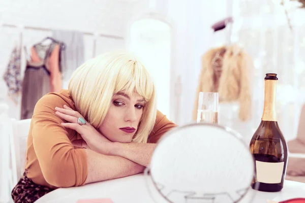 Triste transexual atractiva poniendo su cabeza sobre la mesa — Foto de Stock