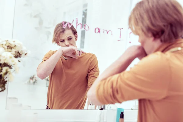 Расстроенный гендерно-странный почерк с помадой на зеркале — стоковое фото