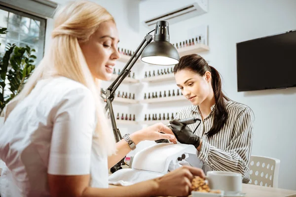 Rubia de pelo visitante de artista de uñas tomando su taza con té verde — Foto de Stock