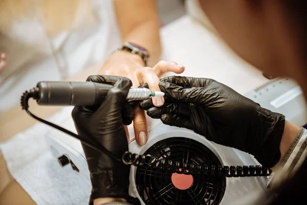 Professional nail artist making machine manicure and polishing nails — Stock Photo, Image