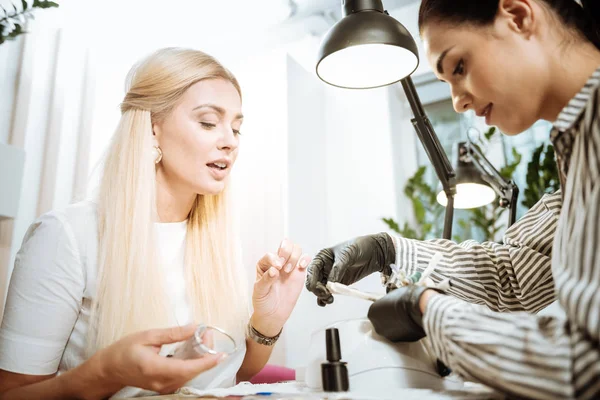 Empresária loira escolhendo a cor da goma-laca da manicura — Fotografia de Stock
