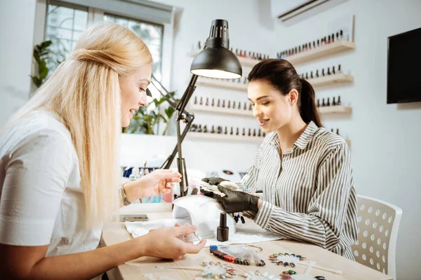 Brillante cliente agradable de artista de uñas comunicándose con ella — Foto de Stock