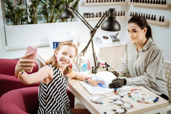 Linda chica adolescente elegante haciendo selfie con su artista de uñas — Foto de Stock