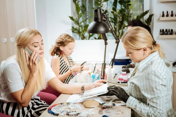 Blonde-haired zakenvrouw spreken telefonisch tijdens manicure — Stockfoto