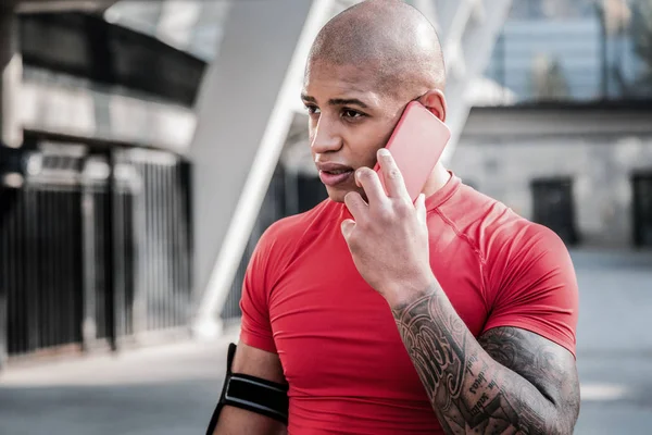 Серьезный приятный спортсмен разговаривает по телефону — стоковое фото