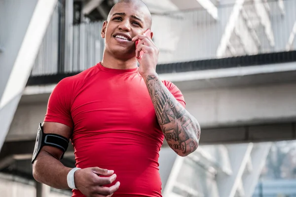 Joyful handsome young sportsman making a call — Stock Photo, Image