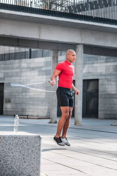 Bello afro americano uomo utilizzando attrezzature sportive — Foto Stock