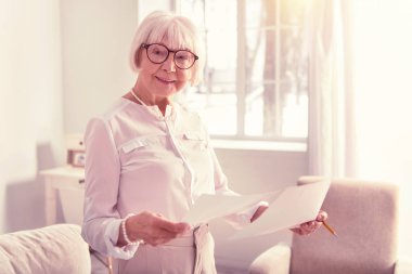 Önemli iş kağıtları taşıyan neşeli gri saçlı adam