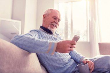 Parlak kıdemli yeni cep telefonunu kontrol