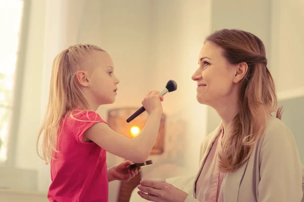 Agradable chica rubia haciendo maquillaje para su mamá —  Fotos de Stock