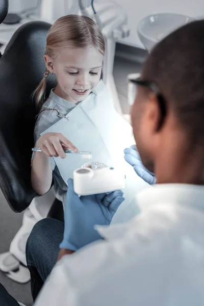 Typ blond flicka tittar på konstgjord käke — Stockfoto