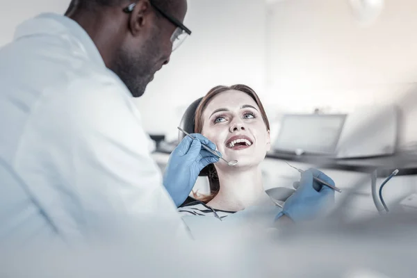 Rodzaj stomatologist międzynarodowe badanie jego młodego pacjenta — Zdjęcie stockowe