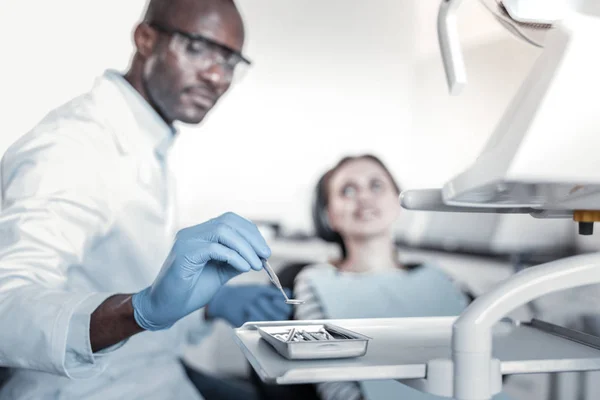 Уважний стоматолог бере інструмент в праву руку — стокове фото