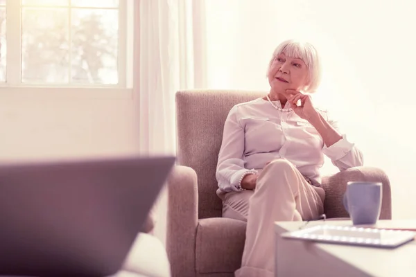 Zamyšlený světlo lady relaxační ve svém obývacím pokoji — Stock fotografie