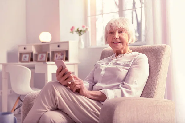 Positiv gråhåriga mogen dam kontrollera hennes telefon — Stockfoto