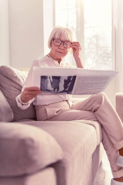 Astuta dama leyendo atentamente un periódico fresco — Foto de Stock