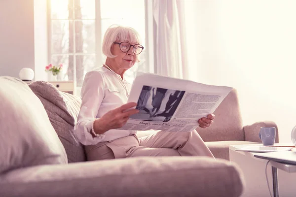 Pensionista actual de pelo gris explorando emocionantes noticias diarias — Foto de Stock