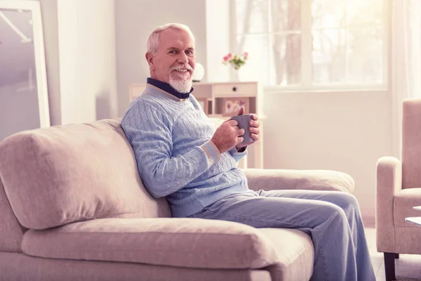 Блуждающий пенсионер с чашкой утреннего кофе — стоковое фото