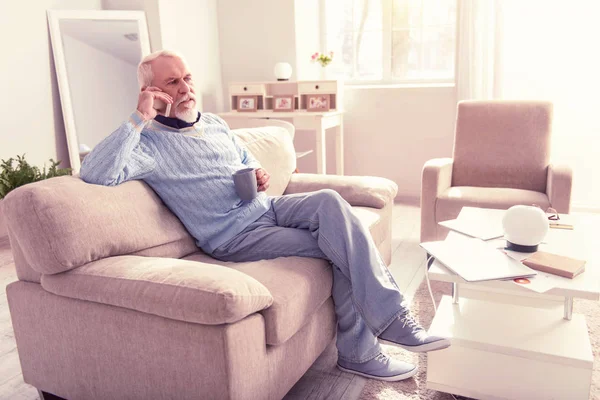 Relajado pensionista guapo que tiene una llamada telefónica importante — Foto de Stock