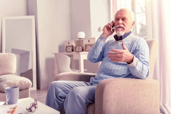 Tidy grey-haired senior respondiendo a una llamada urgente — Foto de Stock