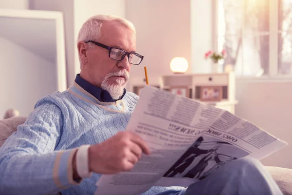 Hombre mayor concentrado pensativo leyendo noticias frescas — Foto de Stock