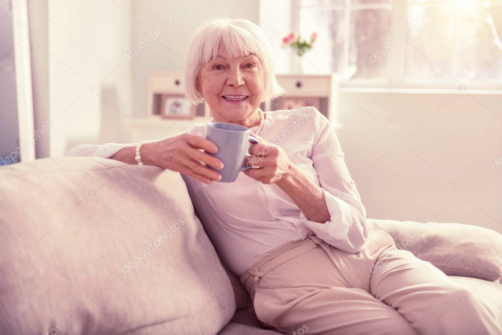 Grey-haired elderly woman enjoying her spare time