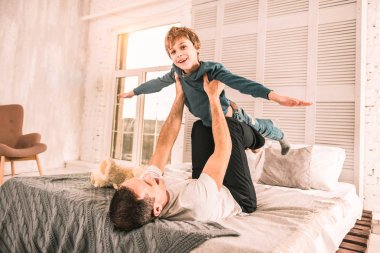 Küçük hayalperest, babasıyla oynarken bir uçak gibi davranan heyecanlı.