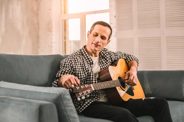 Hardwerkende nieuwsgierig man hard gewerkt aan het bereiken van vooruitgang op zijn gitaar vaardigheden. — Stockfoto