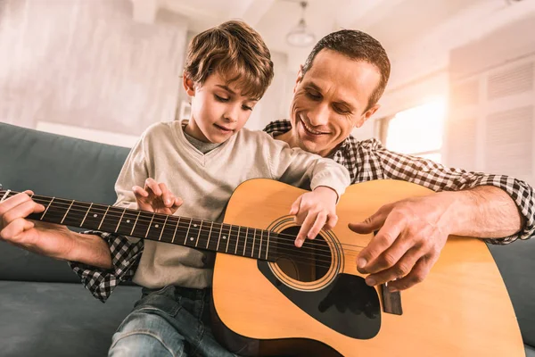 Способный взрослый музыкант критикует своих сыновей за то, что они играют на гитаре . — стоковое фото