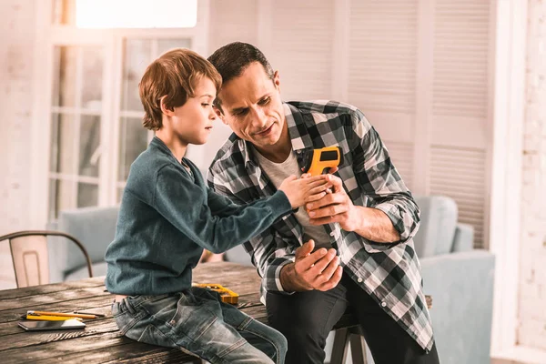 Interesado padre mostrando a su hijo algunas funciones interesantes de su herramienta . — Foto de Stock