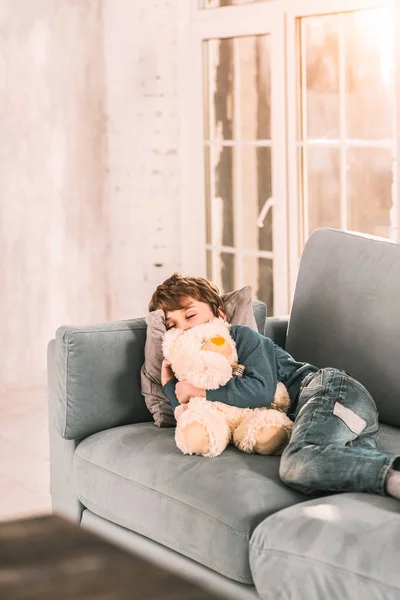 Lindo chico tomando una siesta en el sofá después de un largo día . — Foto de Stock