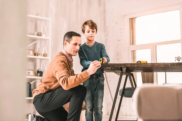 Demonstração adulta séria inteligente como usar uma fita métrica para seu filho . — Fotografia de Stock