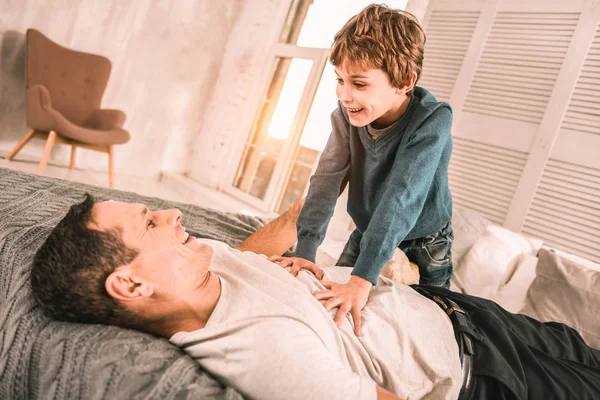 Criança excitada ambiciosa contando a seu pai atencioso uma piada inteligente . — Fotografia de Stock