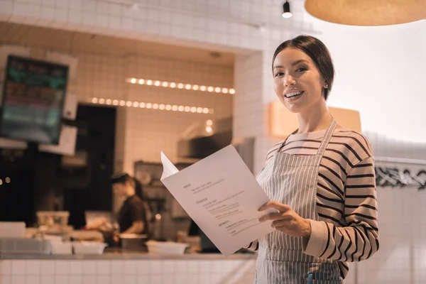 Apelando bela mulher segurando menu de seu restaurante — Fotografia de Stock