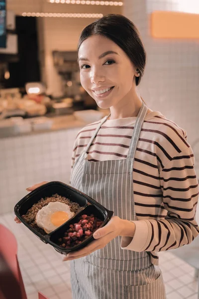 Stralend aangename serveerster houden van lekkere Lunchbox voor clients — Stockfoto