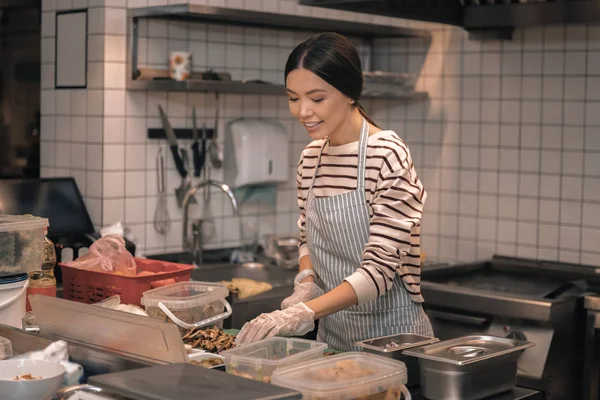 Helper van chef-kok handschoenen snijden voedsel voor salades — Stockfoto