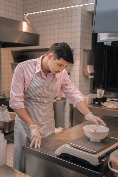 Chef de pelo oscuro que mide la ensalada antes de servirla al cliente — Foto de Stock