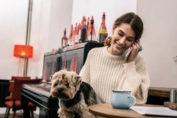Nő, ami egy telefonhívás közben ül egy kávézóban — Stock Fotó