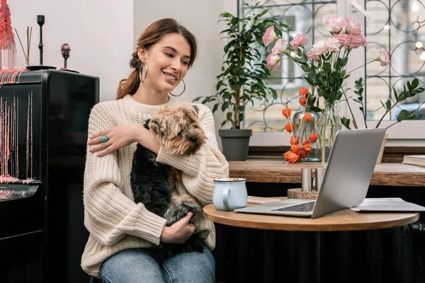 Женщина, работающая в кафе со своей собакой — стоковое фото