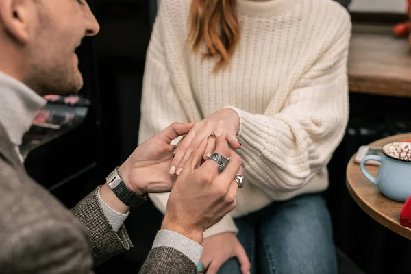 Hombre poniendo un anillo en su dedo socios — Foto de Stock